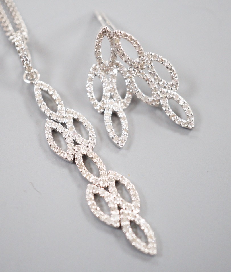 A modern 18ct white gold and diamond chip set septuple oval cluster pendant, overall 42mm, on an 18ct white gold fine link chain, 39cm and a pair of matching earrings, 21mm, gross weight 7.4 grams.